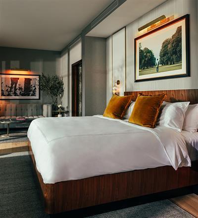 A bed in one of the hotel rooms at The Global Ambassador