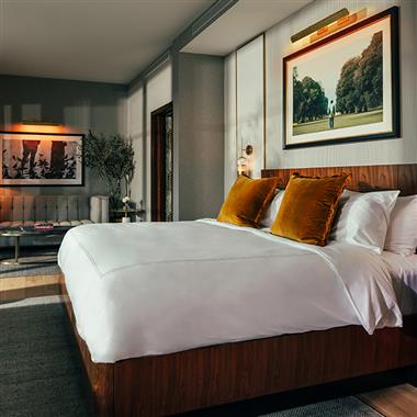 A white bed in a hotel room at The Global Ambassador