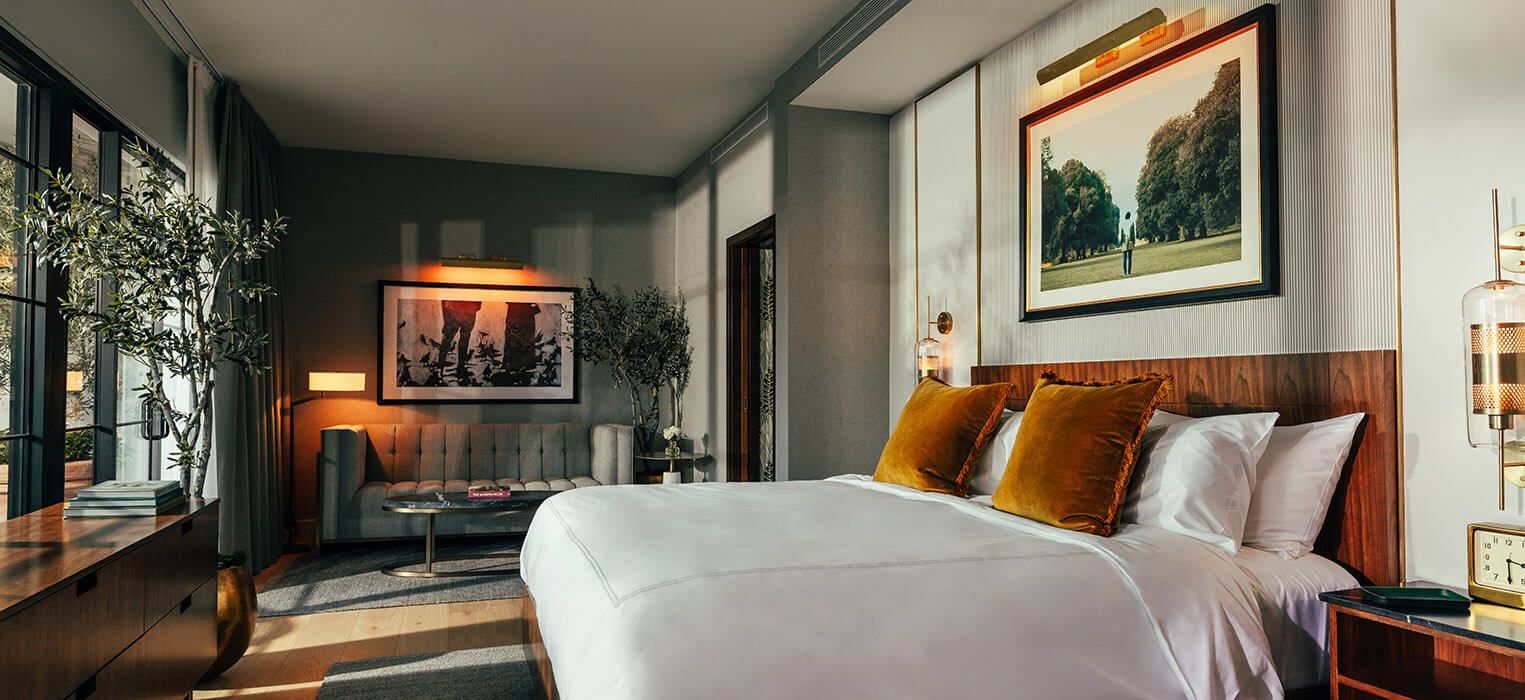 Bedroom with a wood headboard, artwork, and lots of natural light